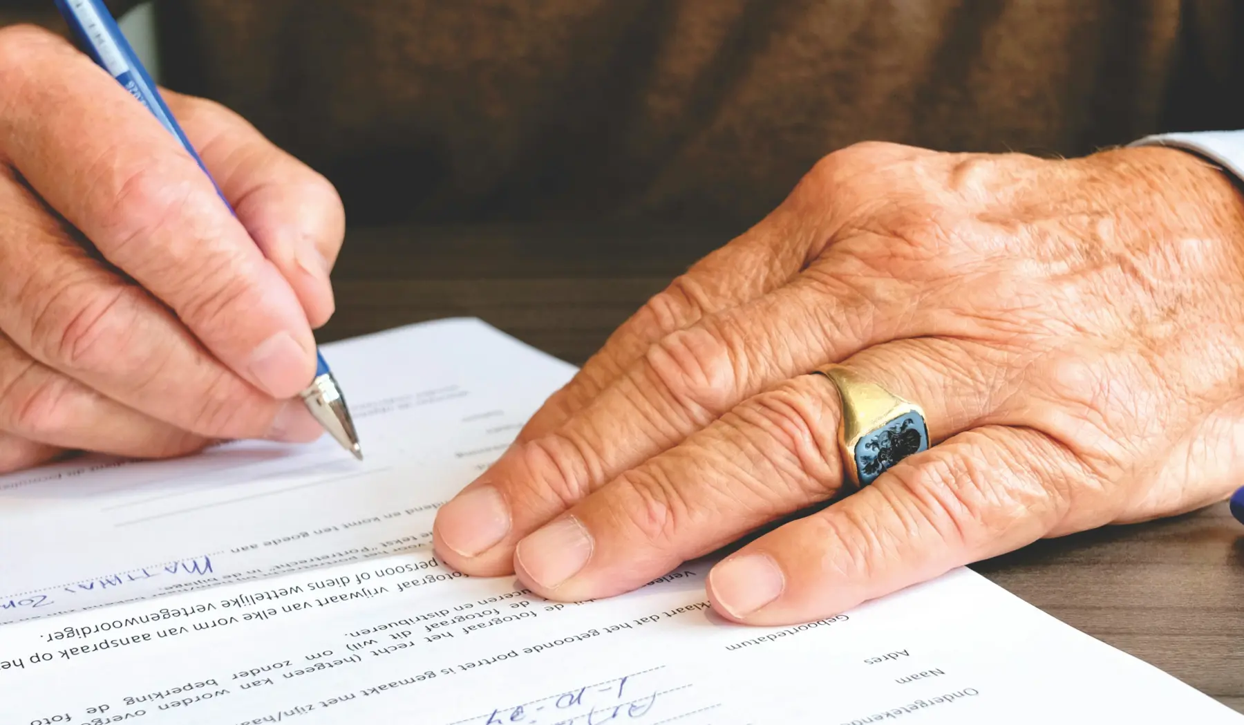 hands signing a legal document